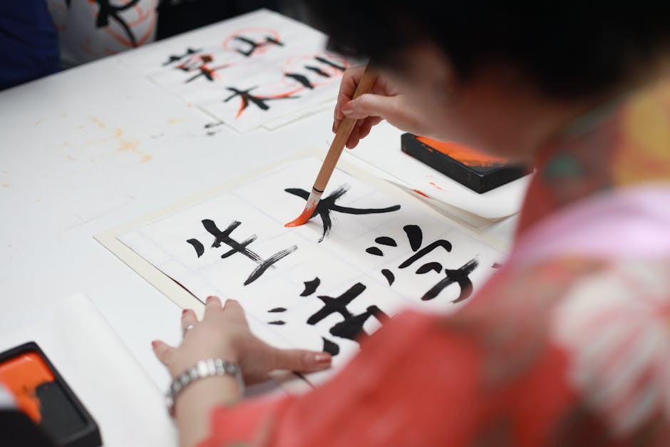 Person practicing Japanese calligraphy with traditional brush and ink