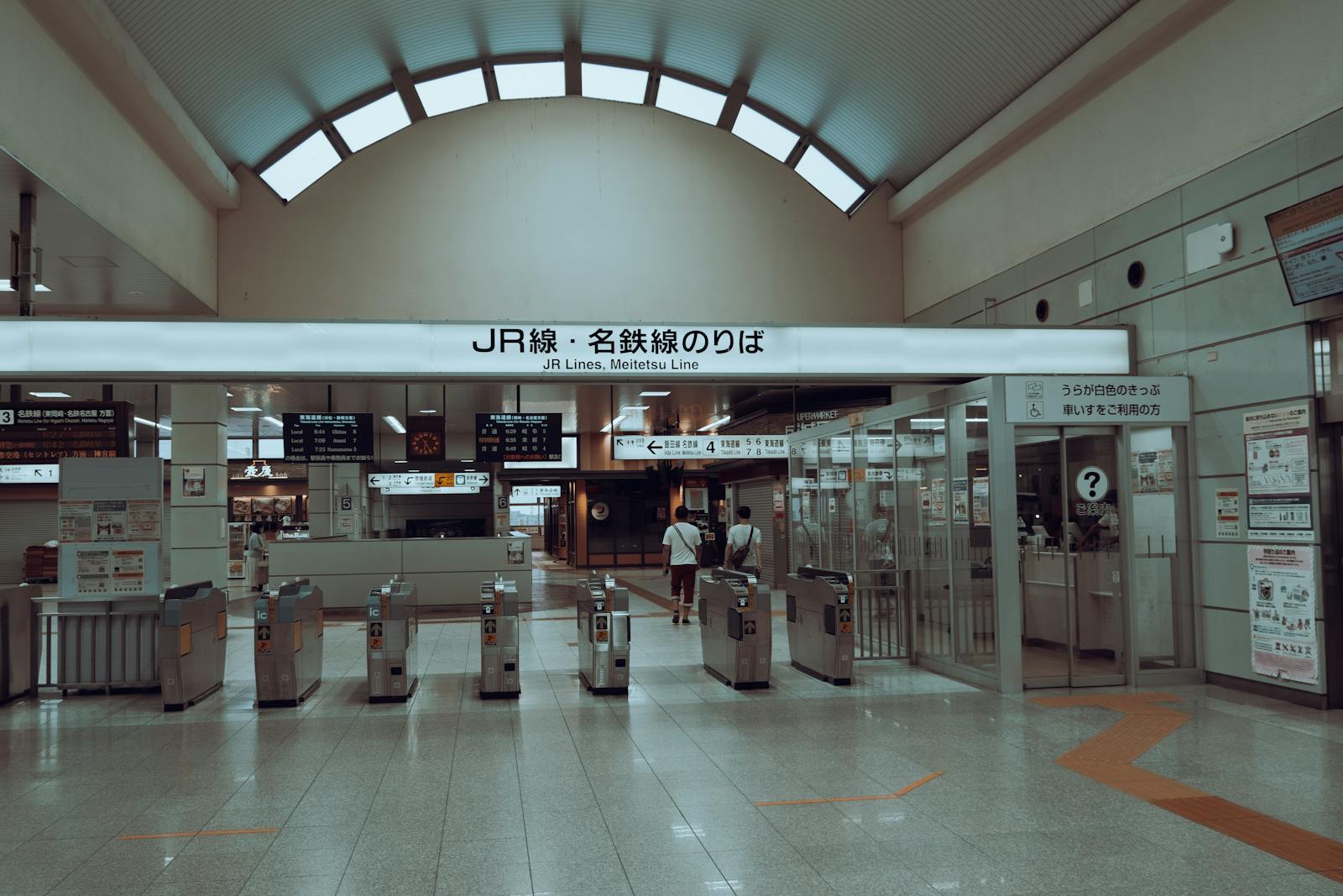 Spacious interior of a Tokyo JR train station with automatic ticket gates