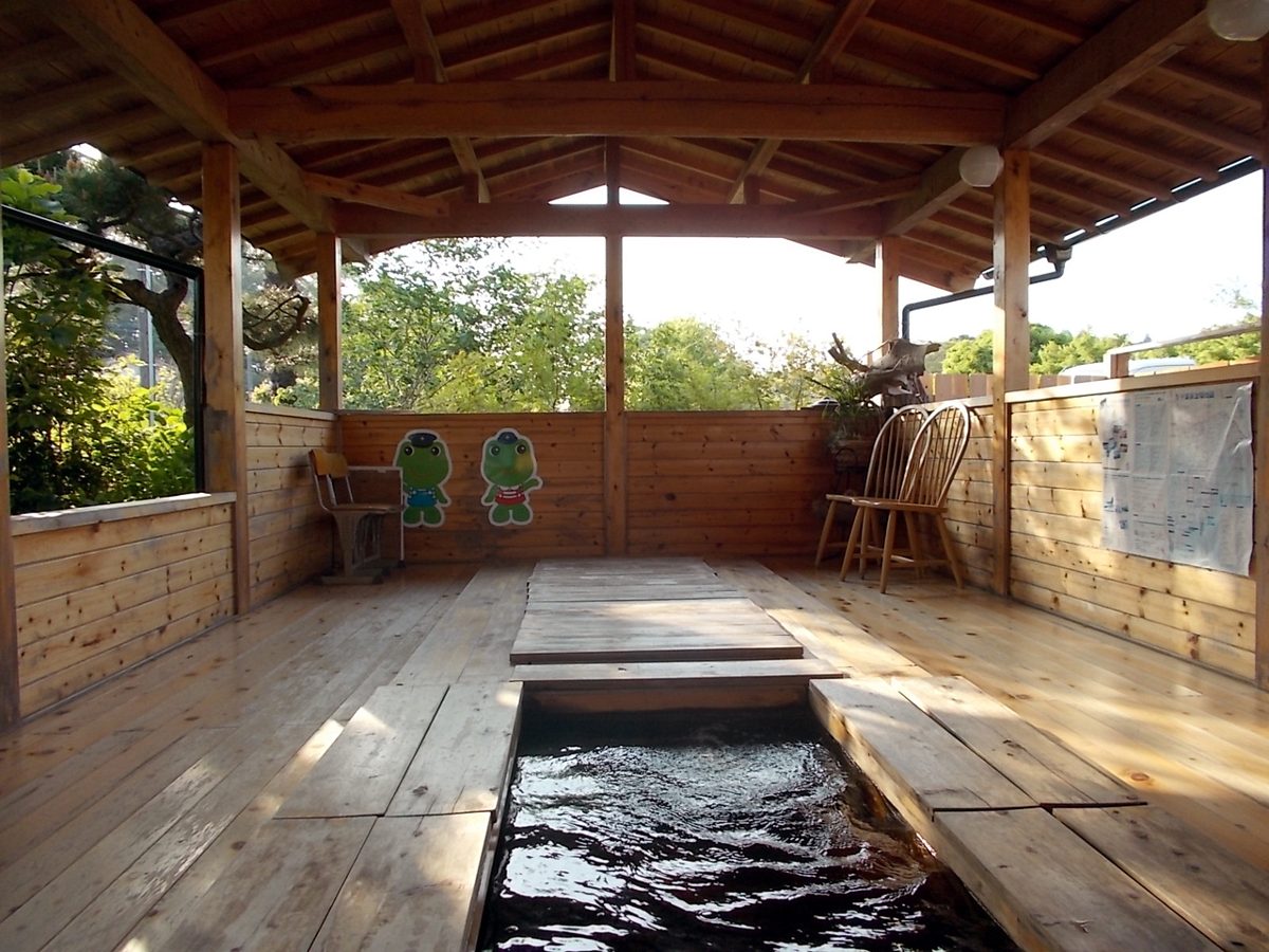 People relaxing with feet in a public ashiyu hot spring footbath in Japan