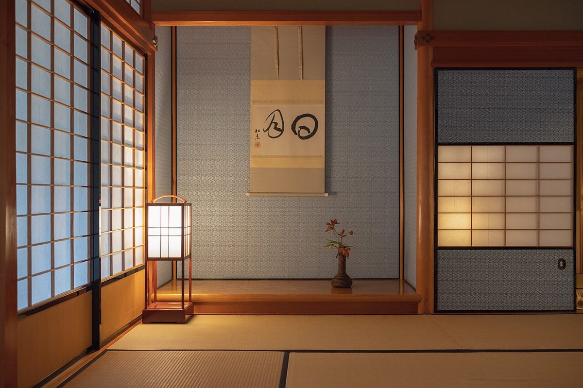 A traditional chashitsu tea room with tatami mats and a hanging scroll in the alcove