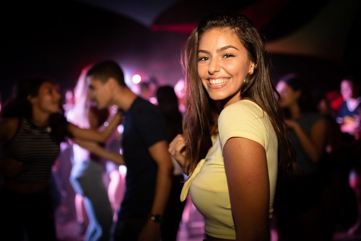 Crowd dancing on a nightclub dance floor under coloured lights