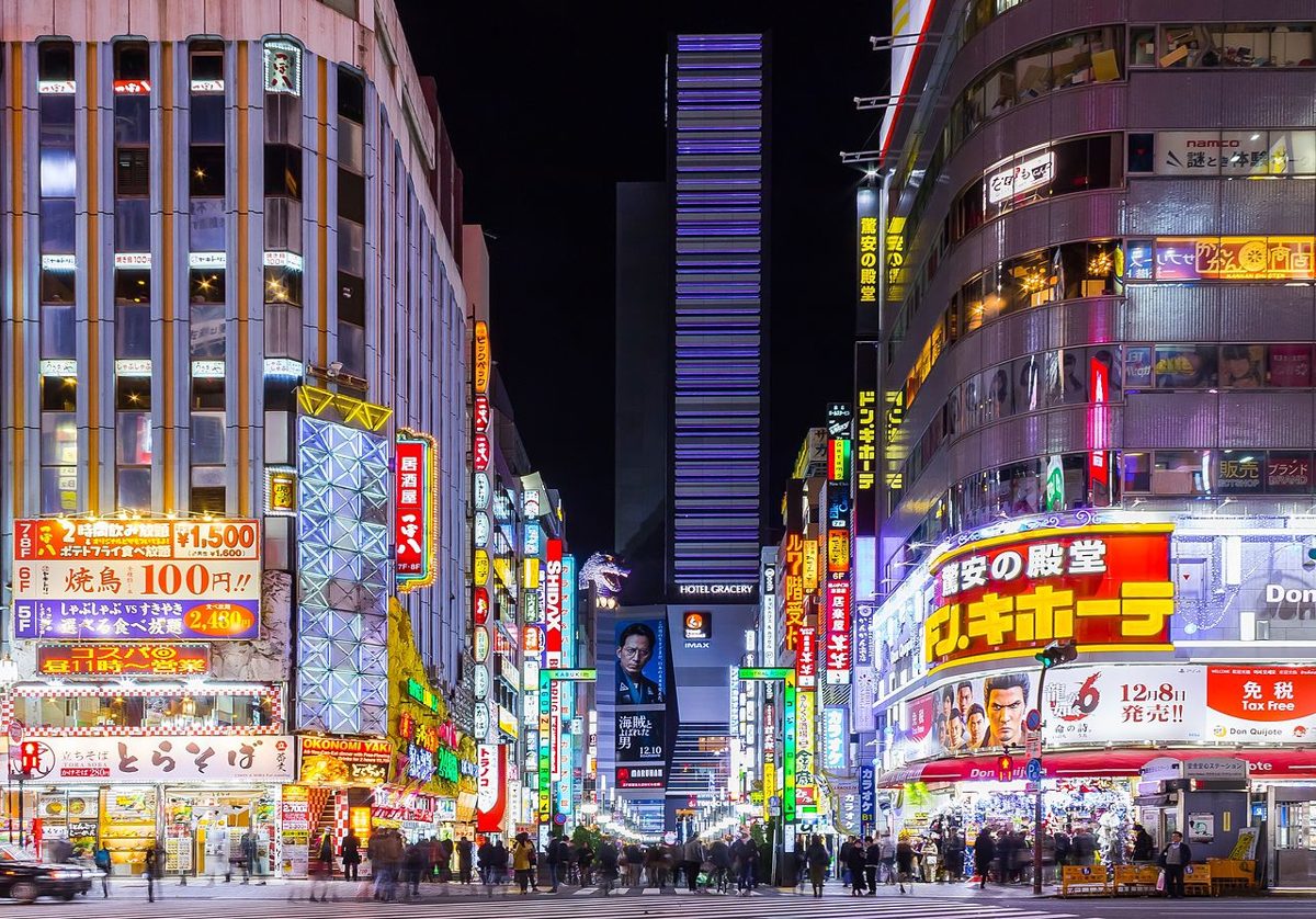 A Don Quijote store glowing among the neon signs of a Tokyo street at night