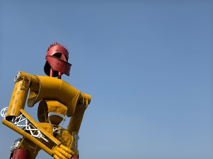 A weathered robot soldier statue in a rooftop garden