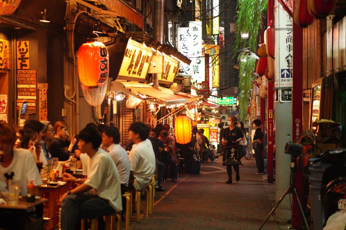 Narrow Golden Gai alley in Shinjuku lined with tiny bars and glowing signs at night