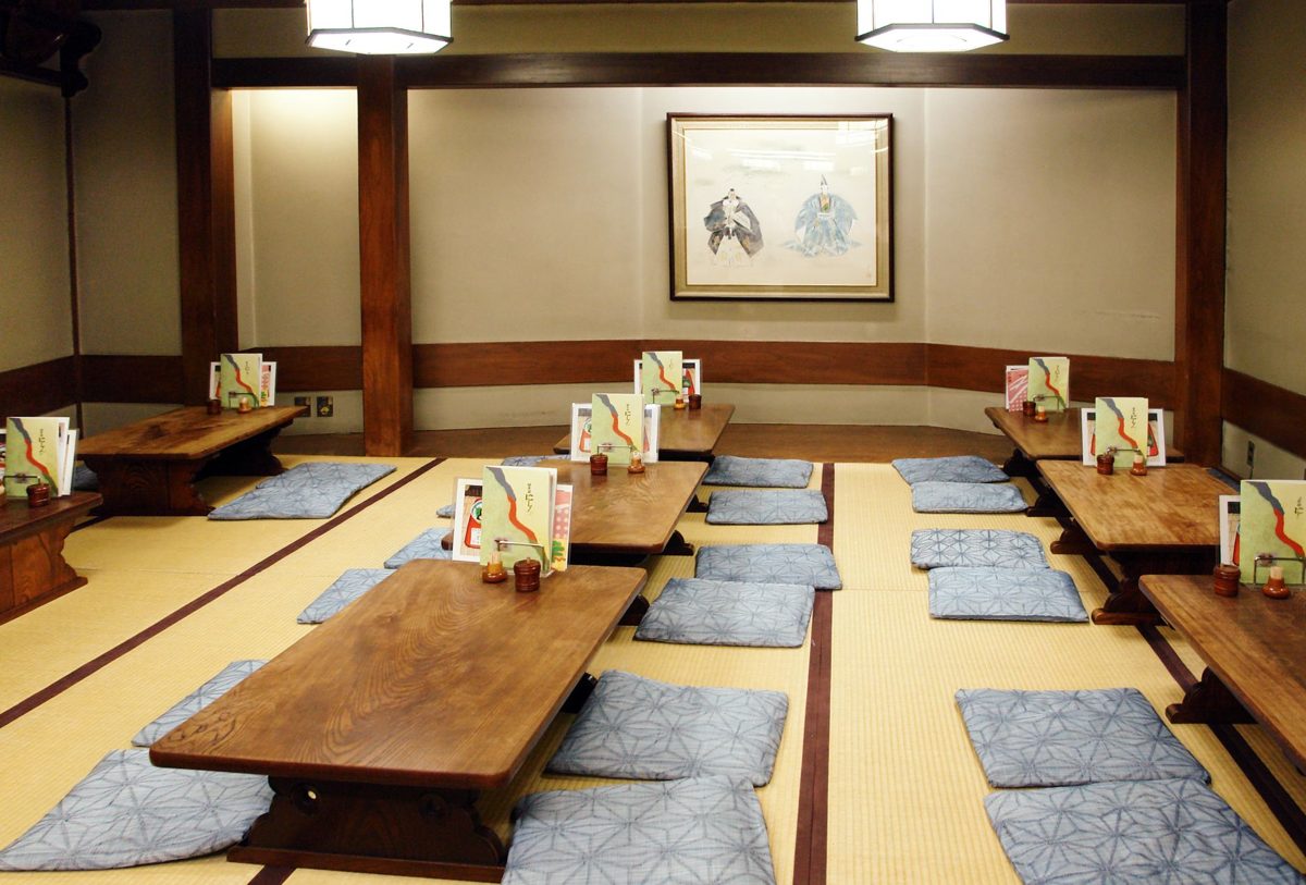 Tatami-mat guest room at a traditional Japanese ryokan with low table and shoji screens