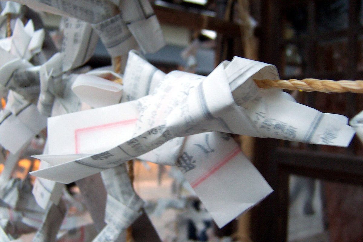 Paper omikuji fortunes tied to a rack at a Japanese shrine