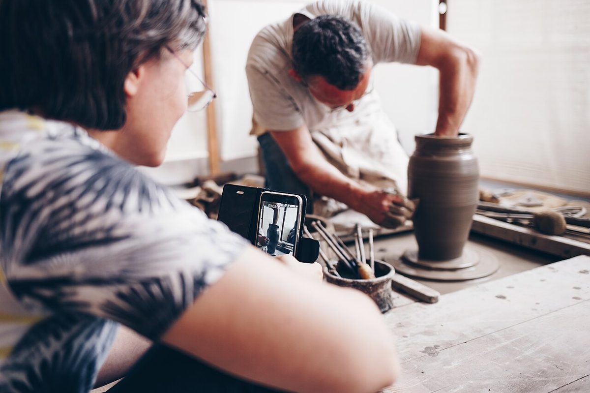 Hands shaping clay on a potter's wheel in a Japanese ceramics studio