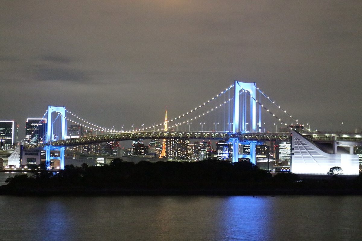 Rainbow Bridge illuminated at night over Tokyo Bay seen from Odaiba