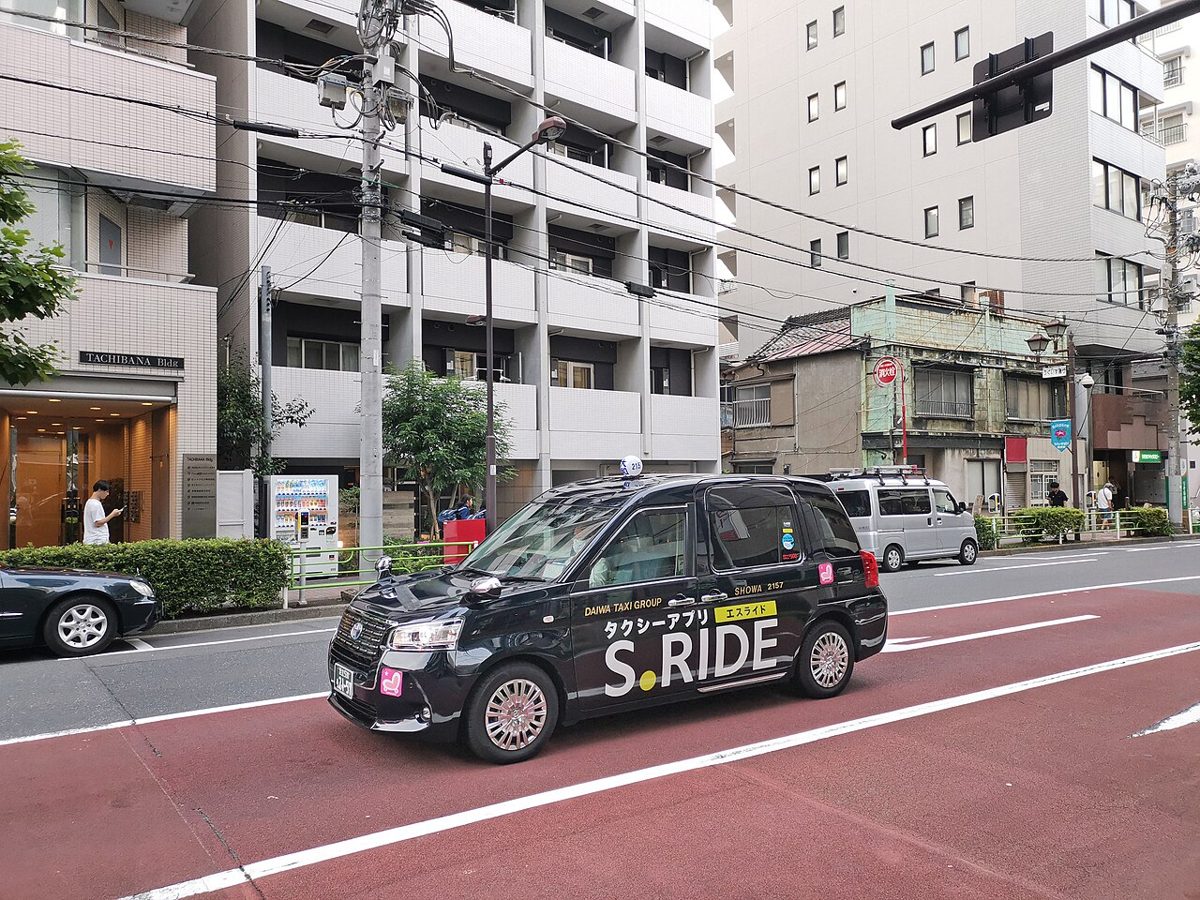 A boxy navy-blue Toyota JPN Taxi on a Tokyo street