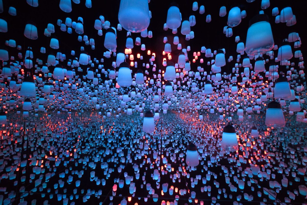 A mirrored room of hanging lamps that shift colour at teamLab Borderless
