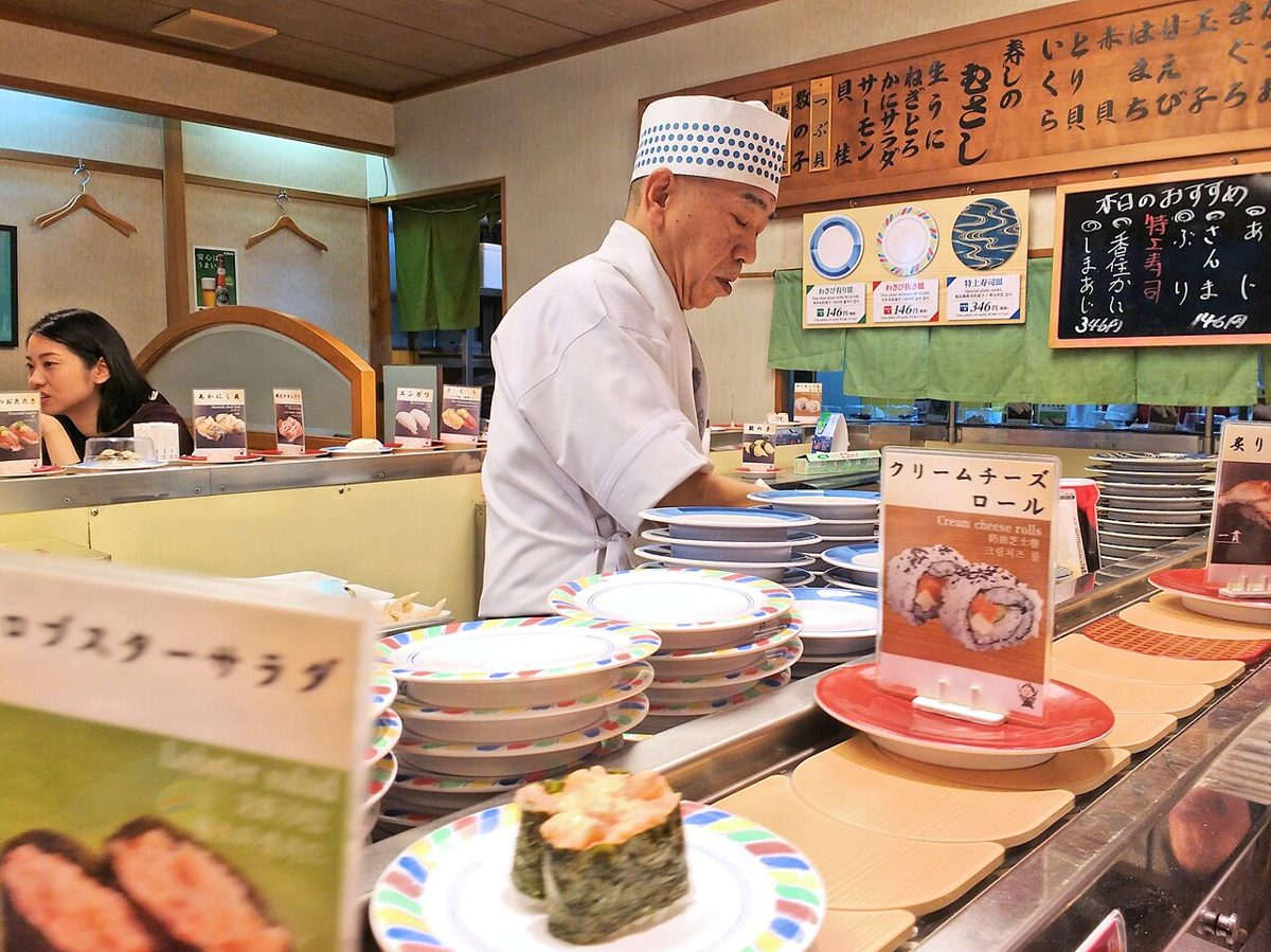 Plates of sushi moving along a conveyor belt at a kaitenzushi restaurant