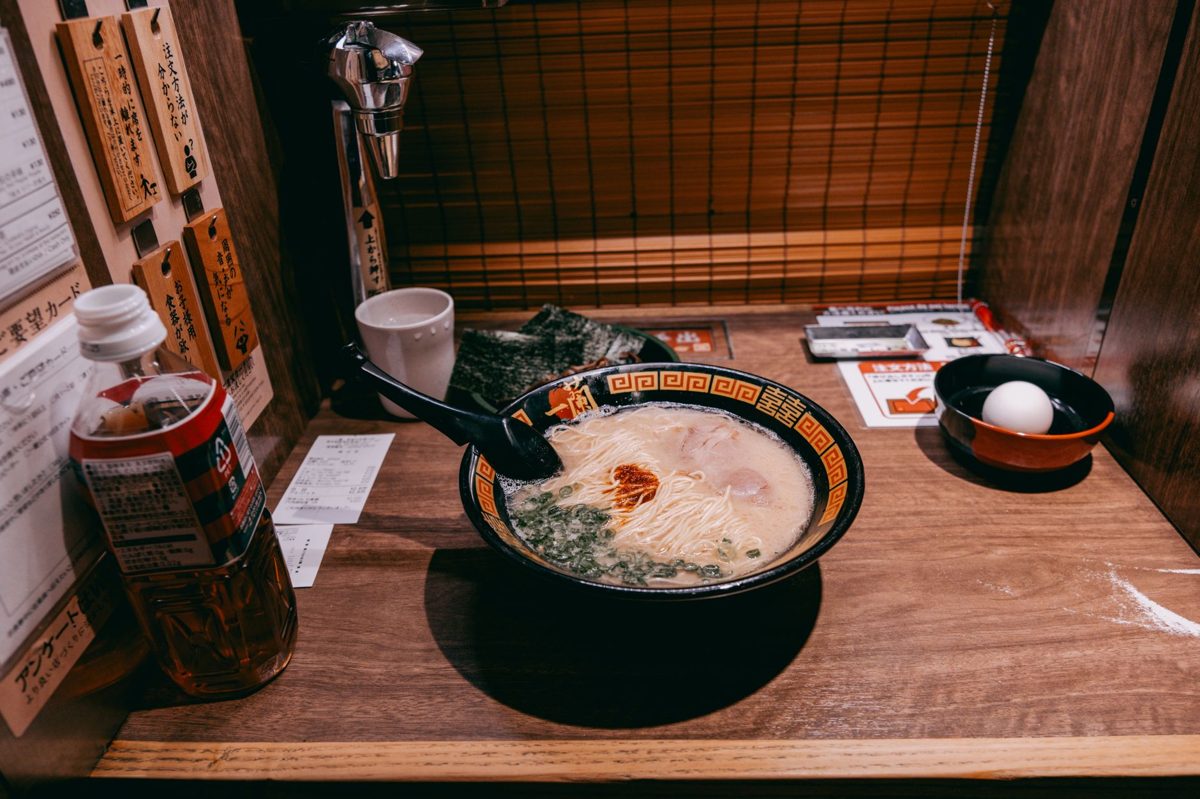 Lifting noodles with chopsticks from a Tokyo ramen bowl