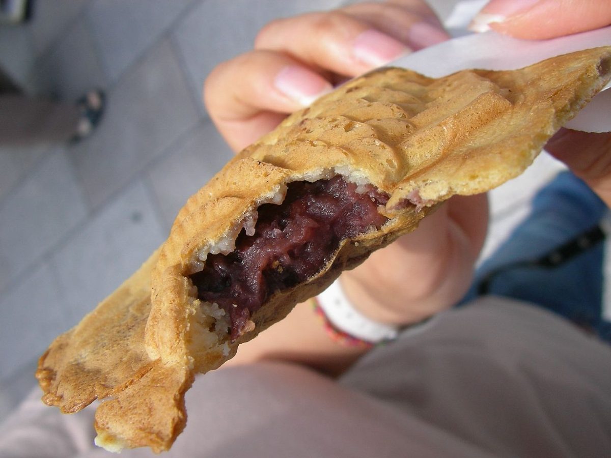 Fish-shaped taiyaki cakes filled with red bean paste cooking in a cast-iron mould