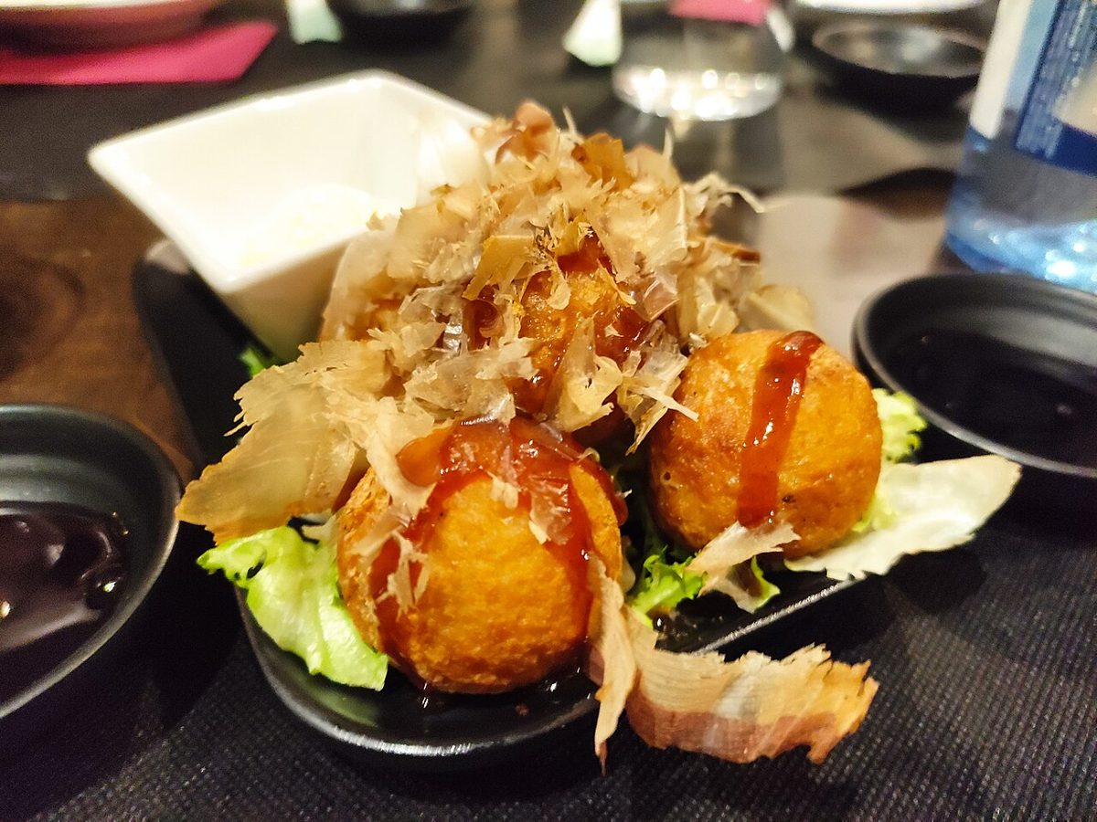 Freshly grilled takoyaki octopus balls topped with bonito flakes and sauce