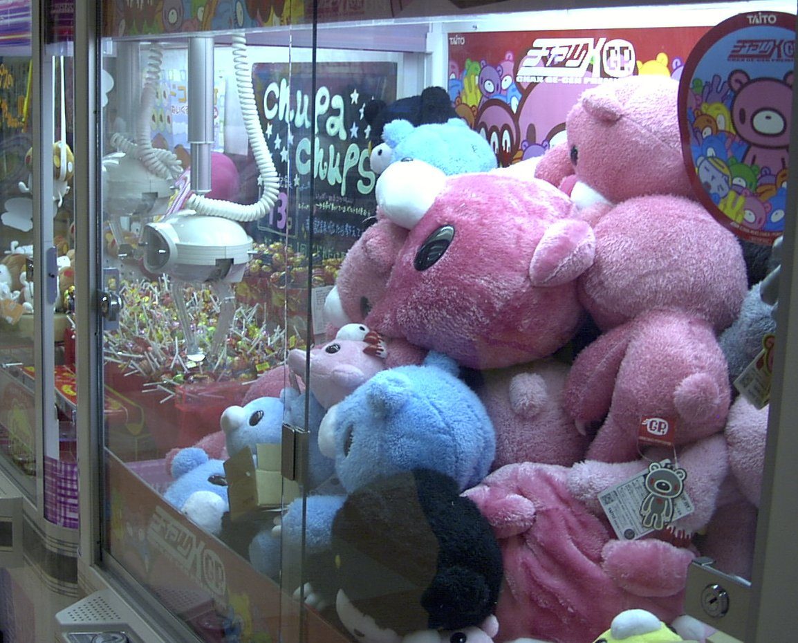 Rows of UFO catcher crane game machines packed with plush prizes in a Tokyo arcade