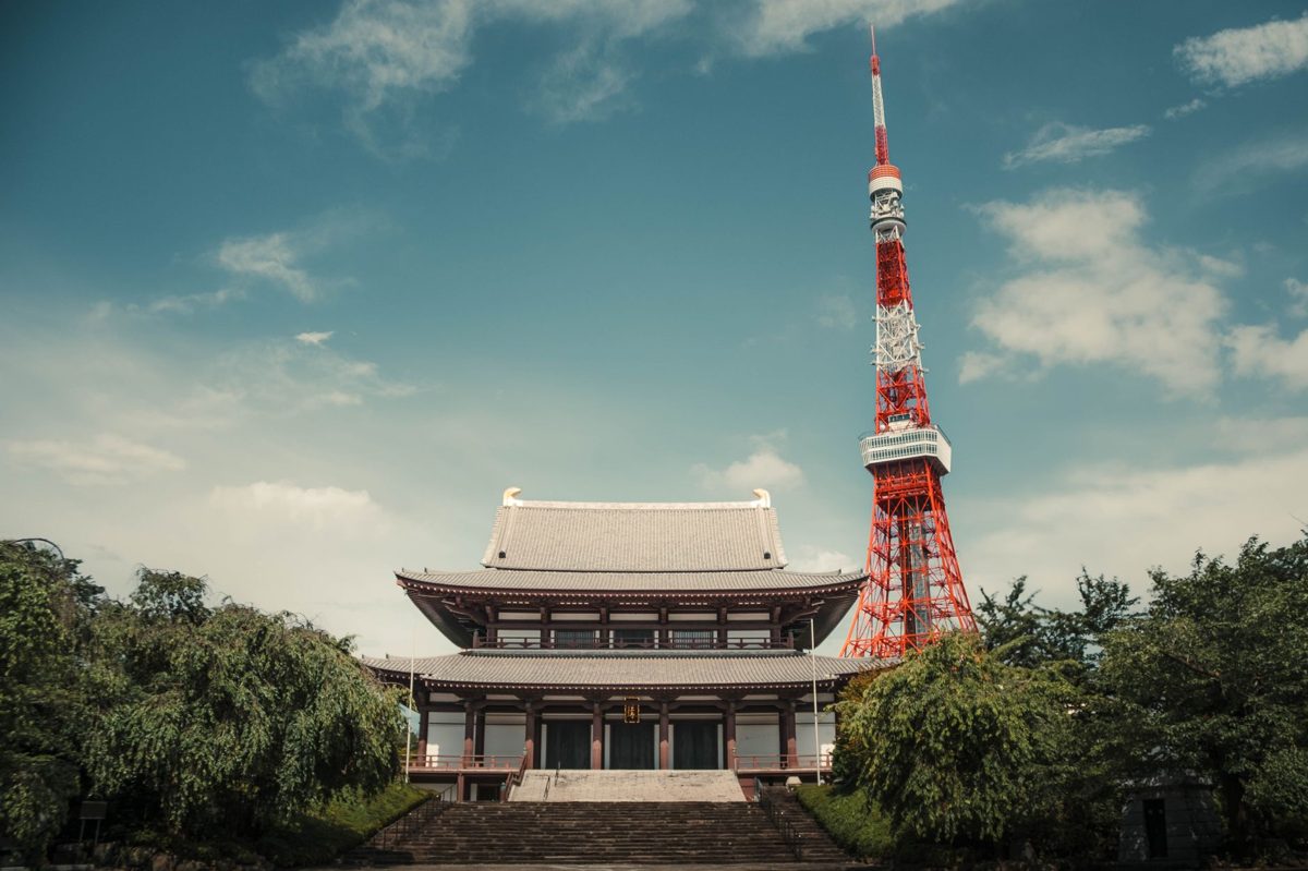 A temple hall with Tokyo Tower rising behind it