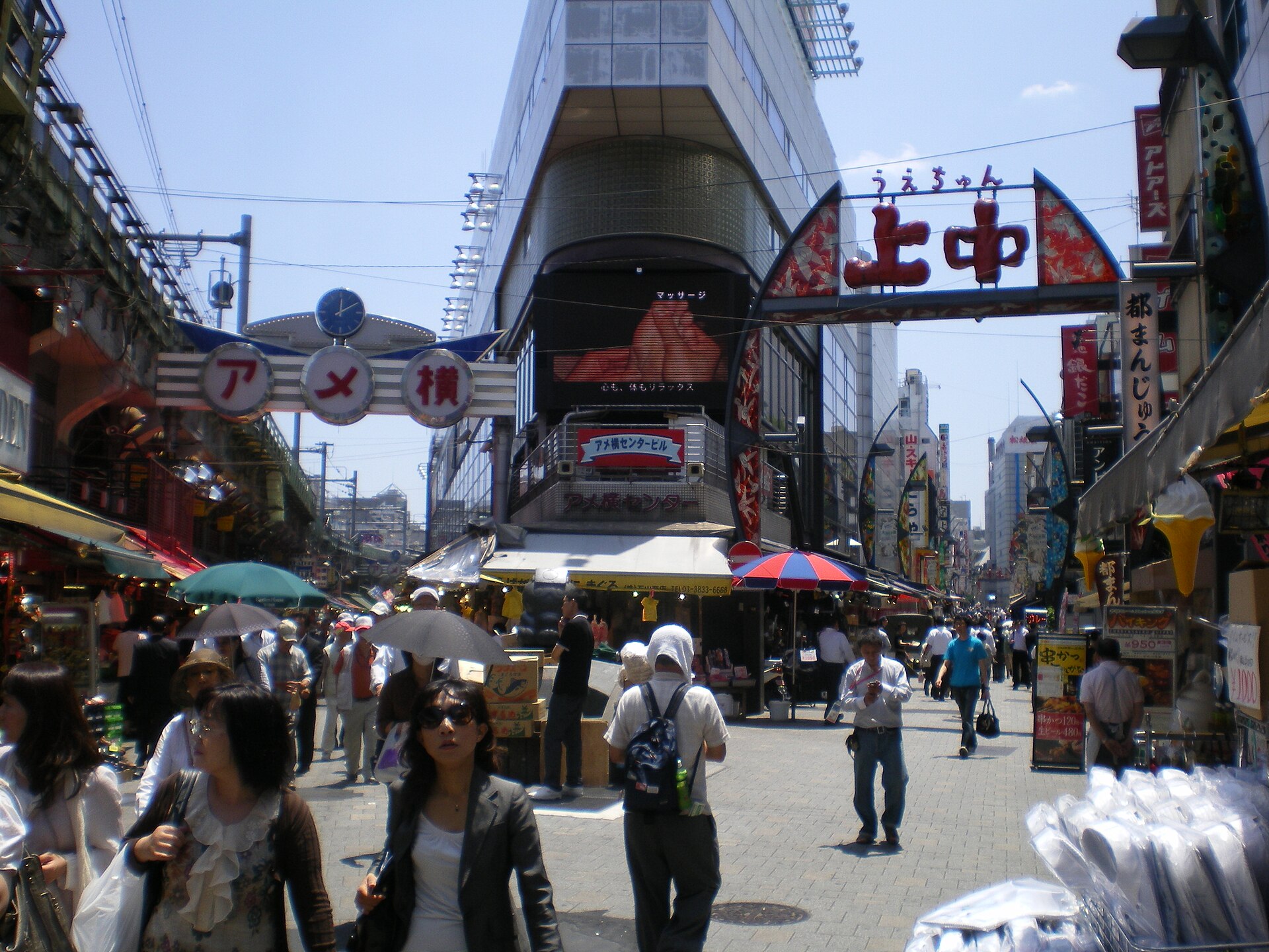 Shoppers and stalls under the Ameyoko market signs beside Ueno station