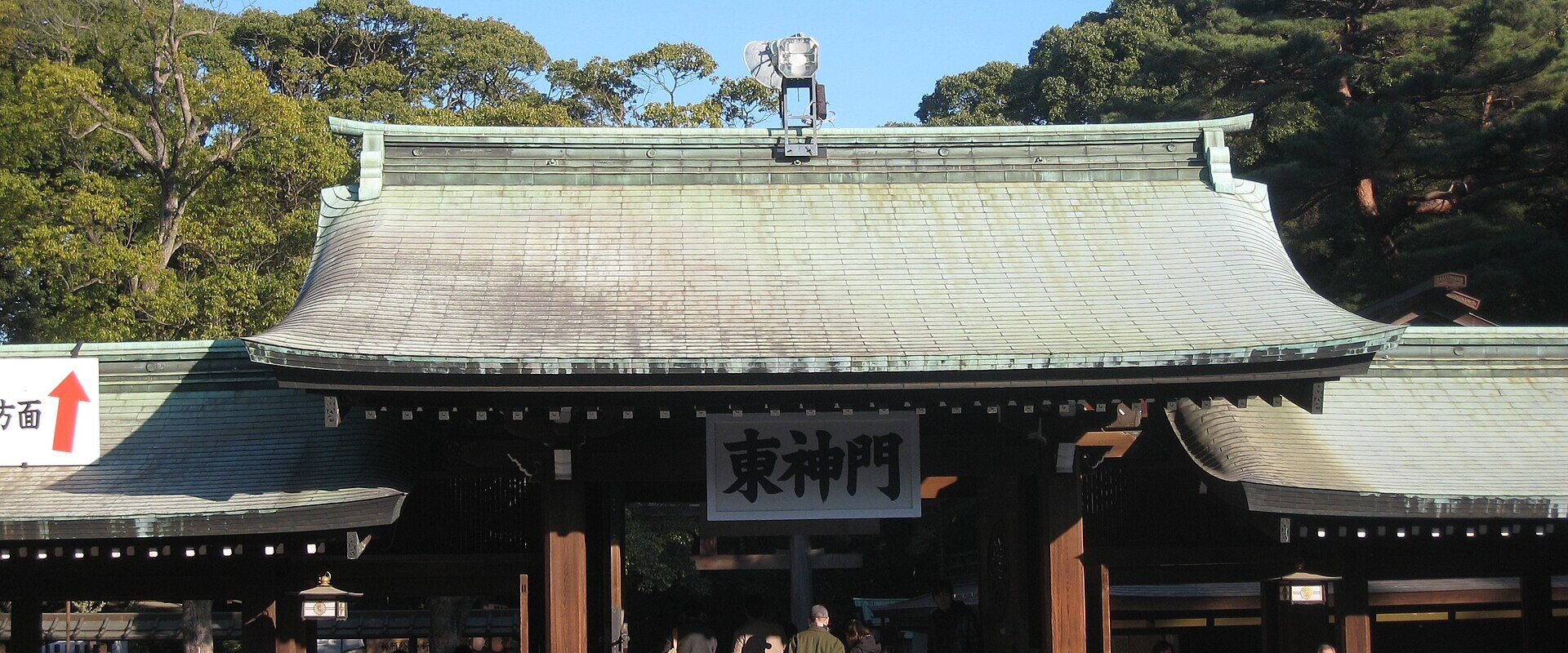 A dense crowd filing through the gate at Meiji Shrine for the New Year hatsumode visit