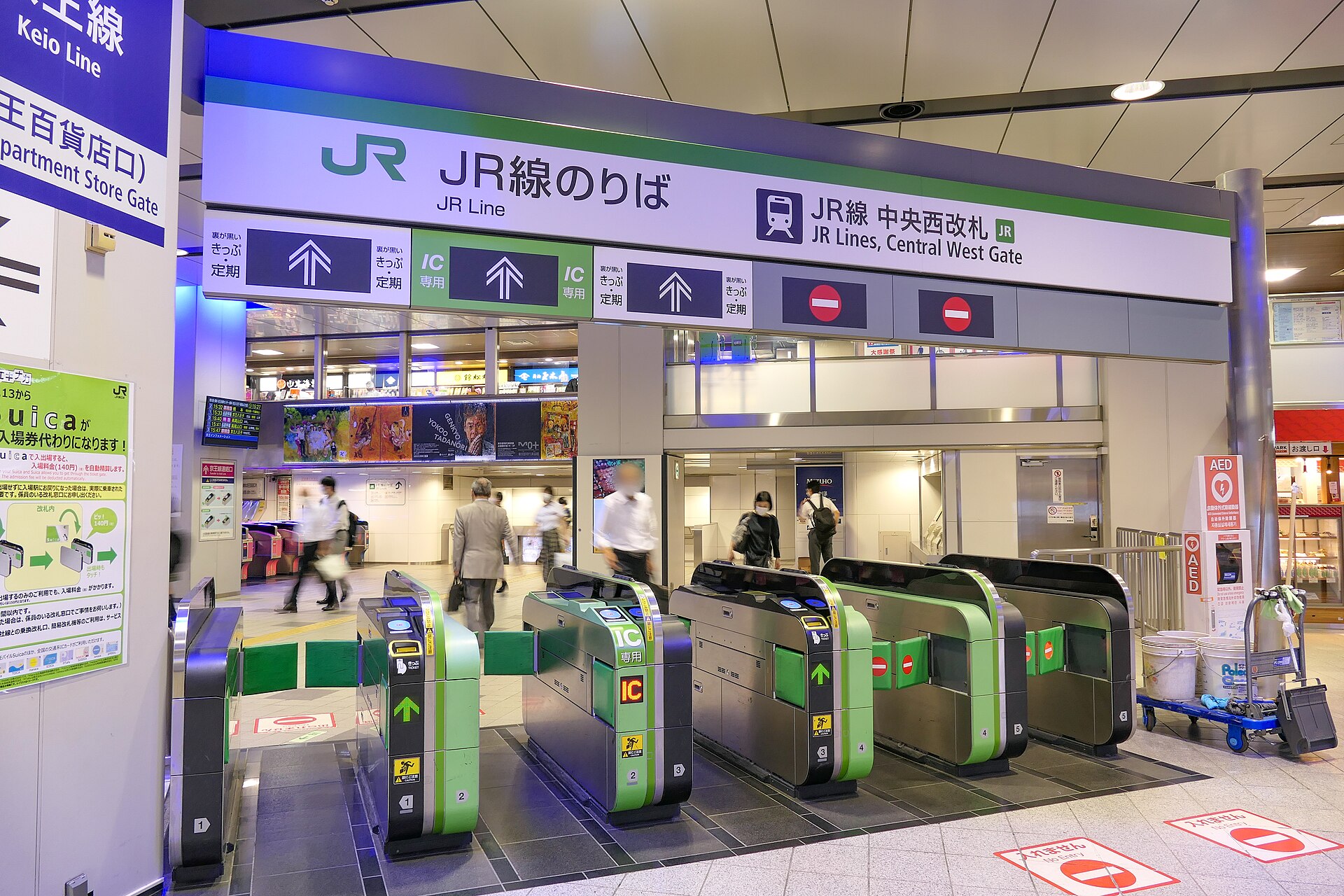 JR Central West Gate at Shinjuku Station with green ticket gates and signs pointing to the Keio and Odakyu lines