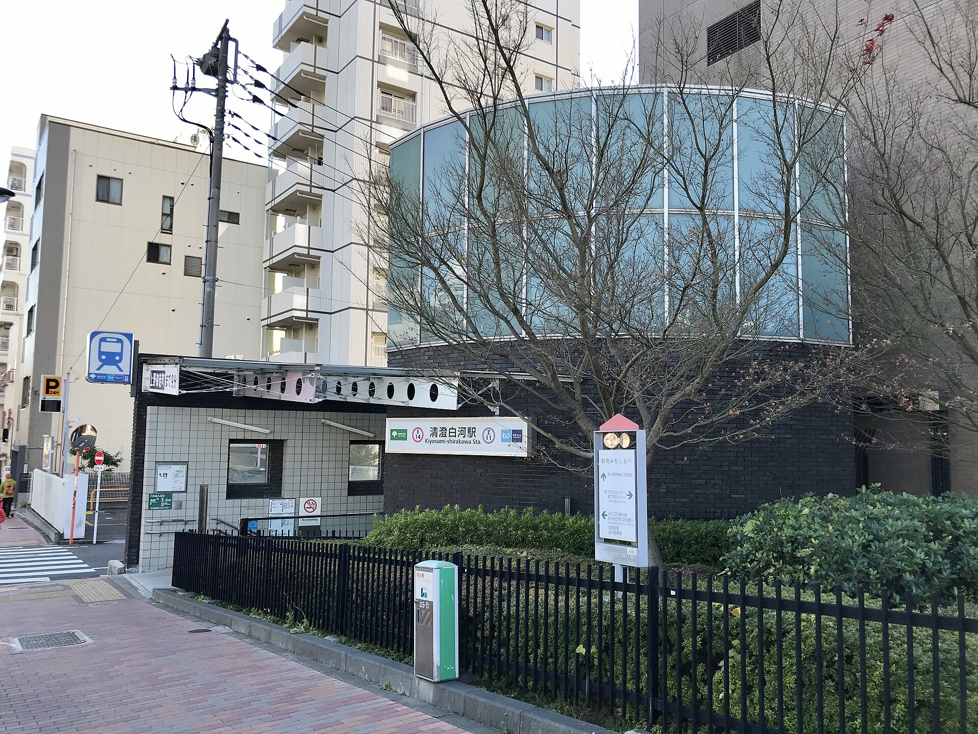 Exit A1 of Kiyosumi-Shirakawa station on a quiet residential street with low buildings and bare winter trees