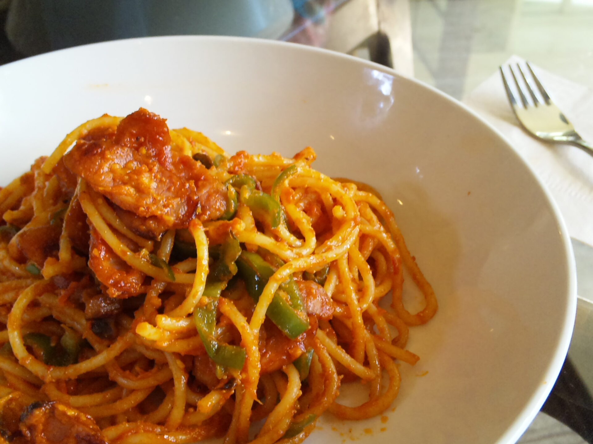 A bowl of naporitan, spaghetti in tomato ketchup sauce with sausage and green pepper