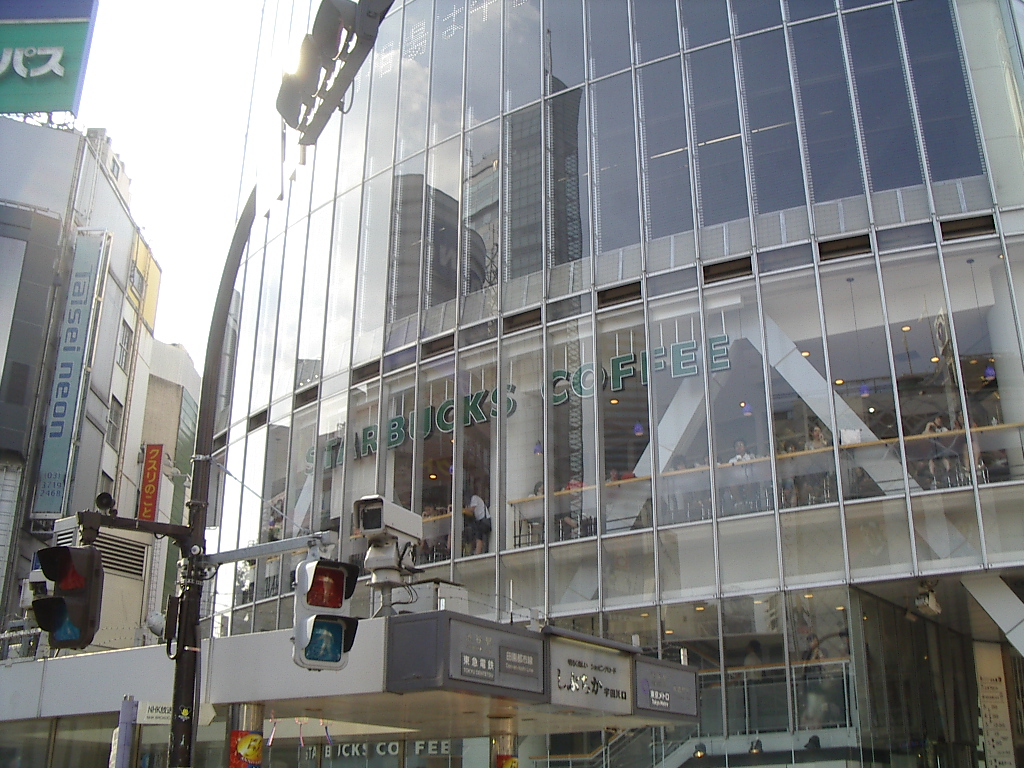 The glass facade of the Tsutaya building in Shibuya with Starbucks Coffee signage across the upper floors