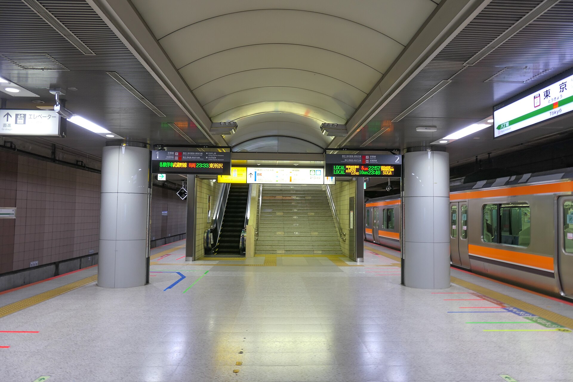 The deep underground Keiyo Line platforms at Tokyo Station with trains on either side of an island platform