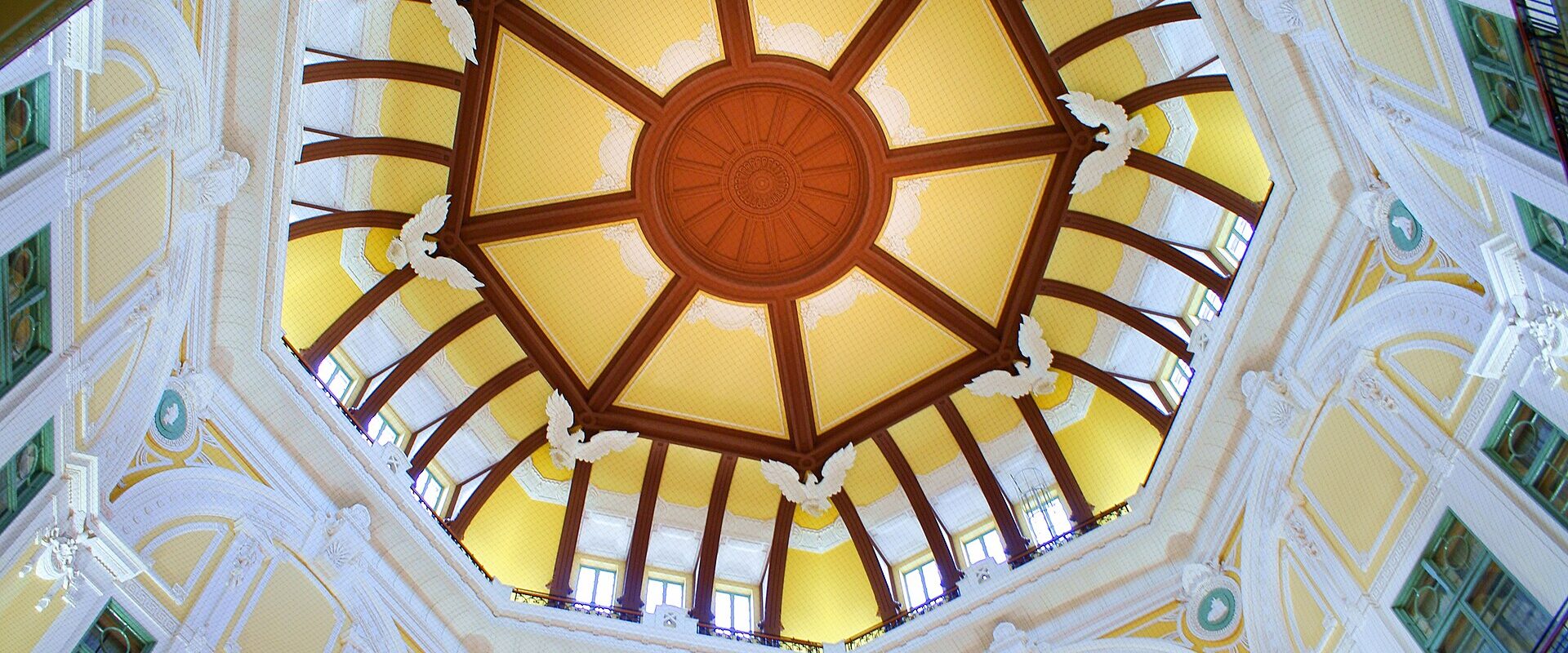 Looking up into the restored dome of Tokyo Station's Marunouchi entrance, with yellow panels, reliefs and an eight-sided pattern