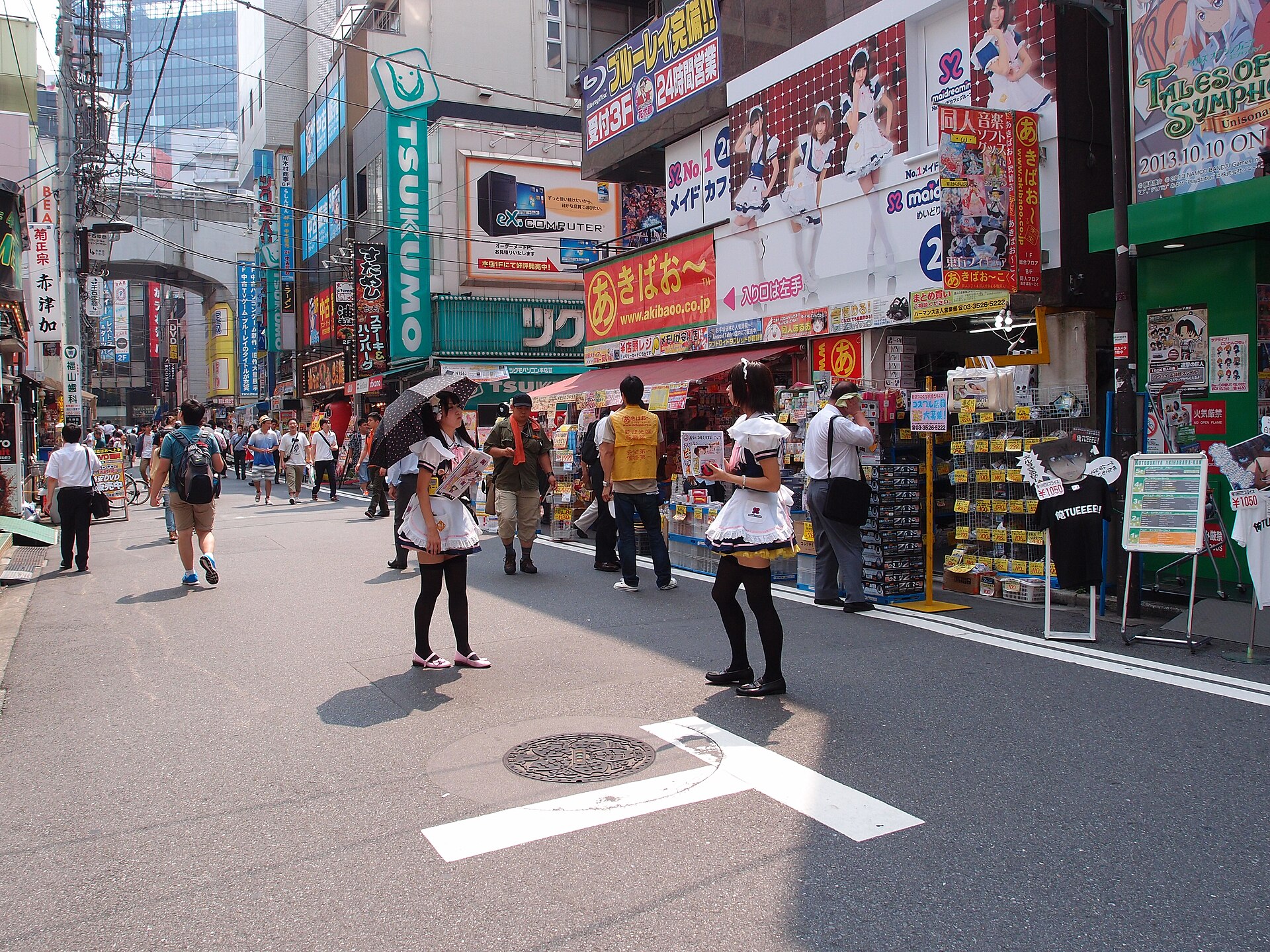 Staff in maid costume handing out flyers on a pedestrianised street in Akihabara