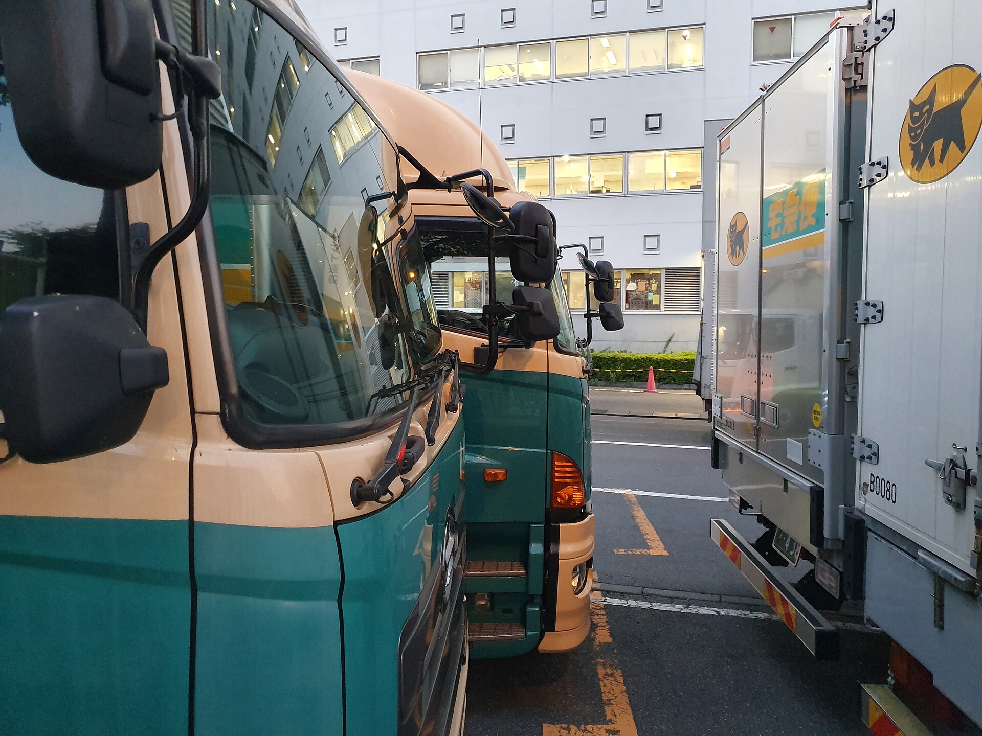 Kuroneko Yamato delivery trucks with the black cat logo parked at a depot in Ariake, Tokyo