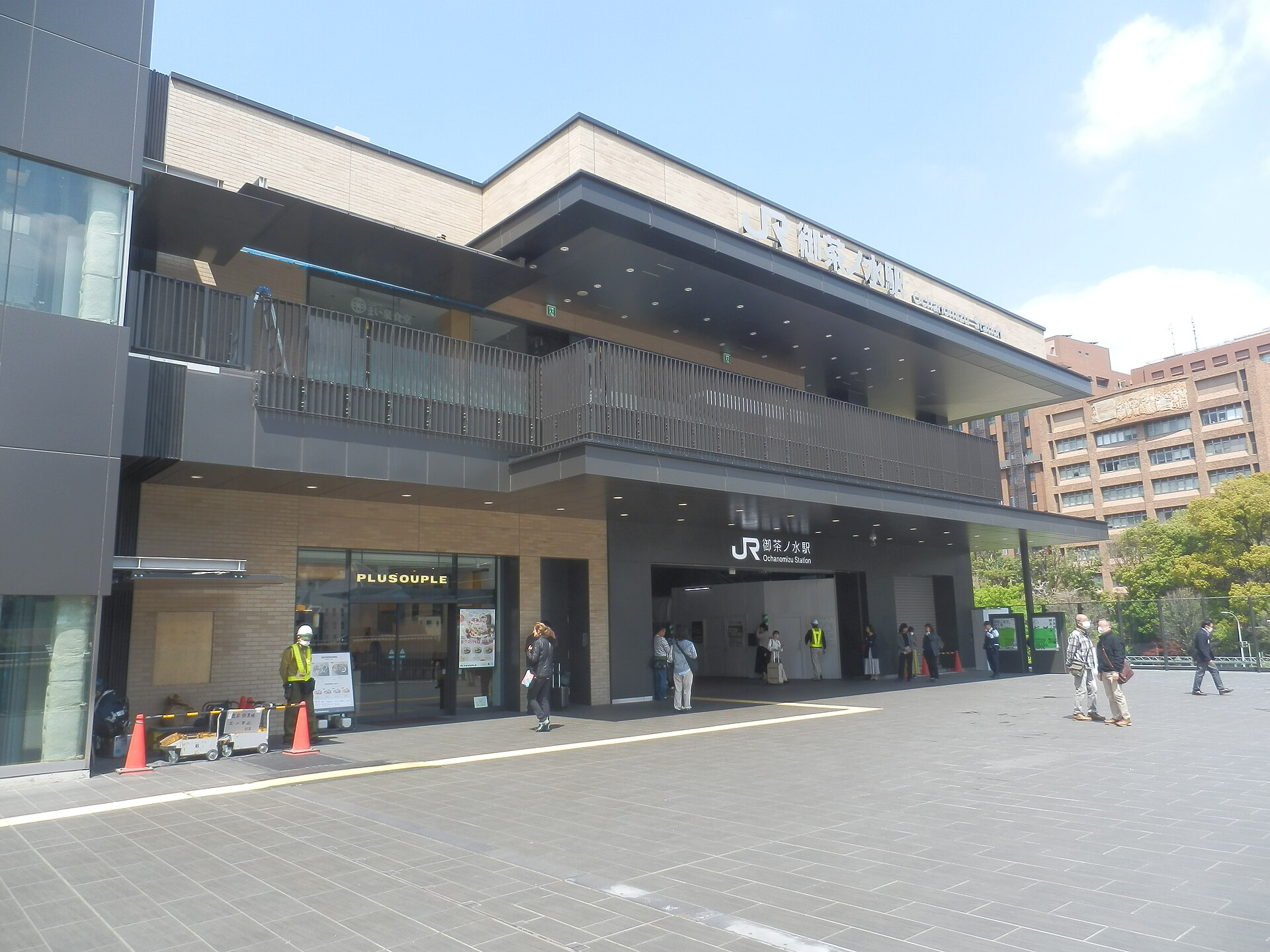 The rebuilt Hijiribashi exit of JR Ochanomizu station, with a wide paved plaza in front, photographed in 2025