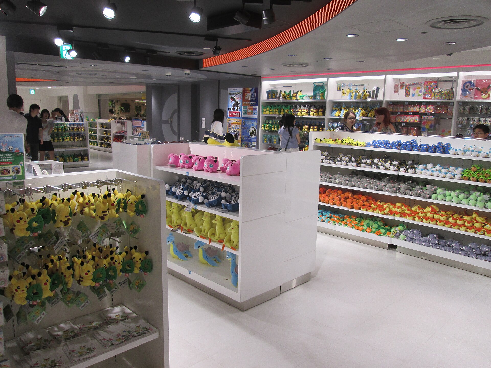 Interior of a Pokemon Center store with walls of plush toys arranged by species