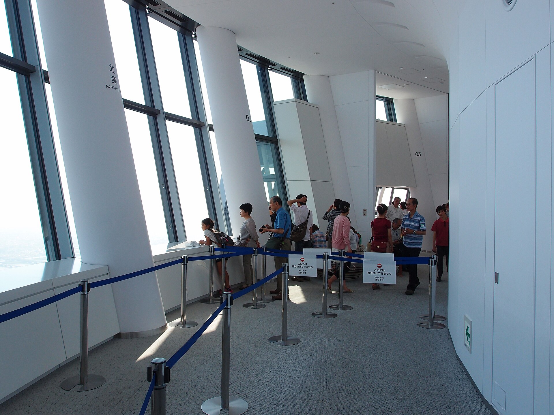 Visitors walking along the sloping glass corridor of the Tembo Galleria inside Tokyo Skytree