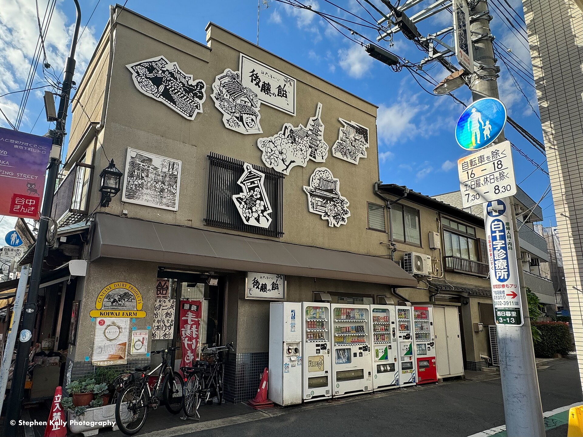 A traditional candy shop in Yanaka Ginza with paper-cut artworks on its facade and a row of vending machines outside